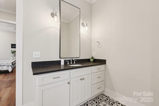 bathroom with ceiling fan, vanity, crown molding, and tile patterned flooring