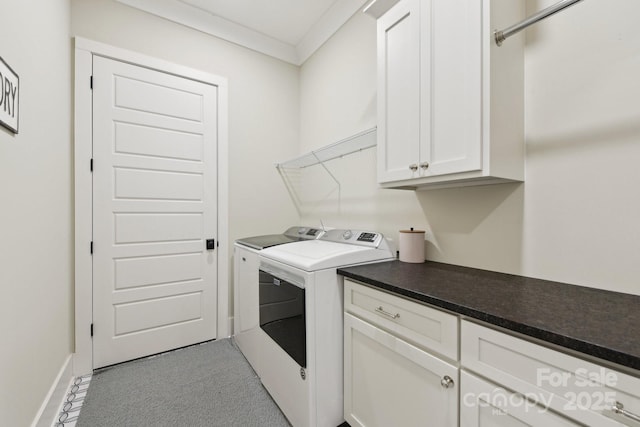 laundry room featuring washing machine and dryer, ornamental molding, and cabinets