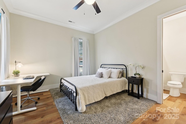 bedroom with ceiling fan, crown molding, connected bathroom, and hardwood / wood-style floors