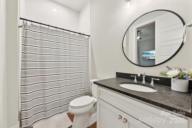 bathroom featuring toilet, ceiling fan, a shower with shower curtain, and vanity