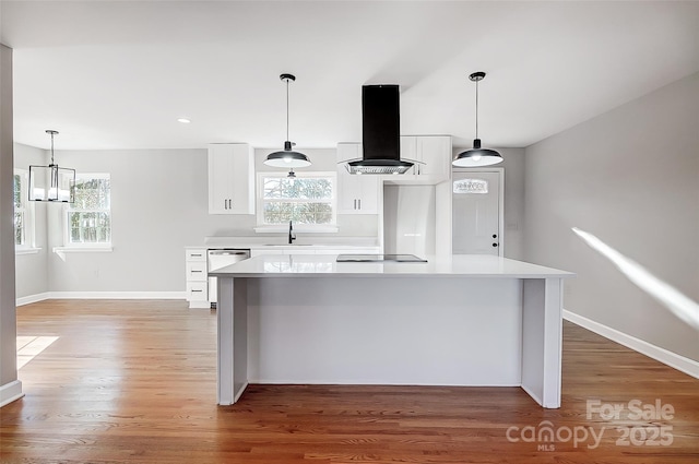 kitchen with a center island, white cabinetry, hanging light fixtures, and extractor fan