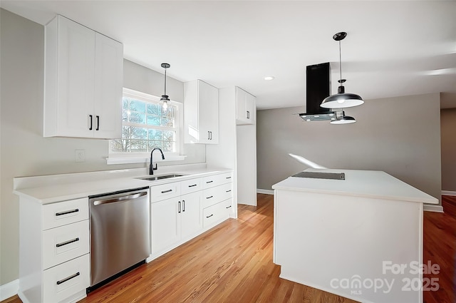 kitchen with hanging light fixtures, white cabinetry, sink, and stainless steel dishwasher