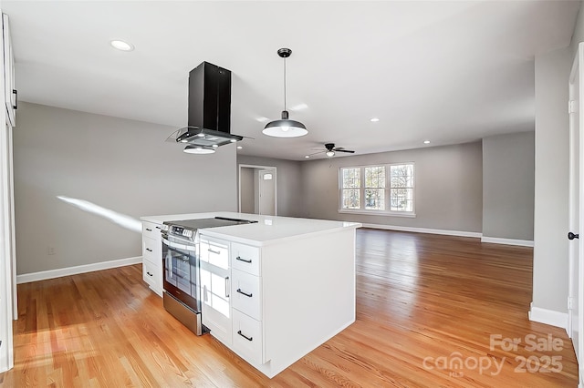 kitchen featuring white cabinetry, island exhaust hood, stainless steel electric range oven, and decorative light fixtures