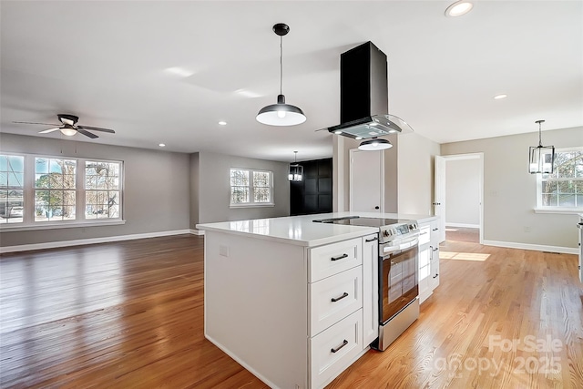 kitchen with white cabinetry, hanging light fixtures, stainless steel electric range, island range hood, and a kitchen island