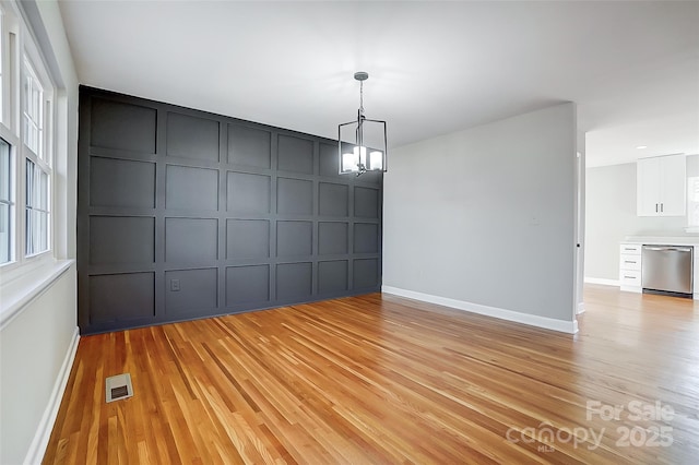 interior space with light wood-type flooring and an inviting chandelier