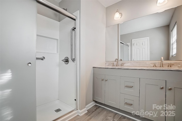 bathroom with vanity, an enclosed shower, and hardwood / wood-style flooring