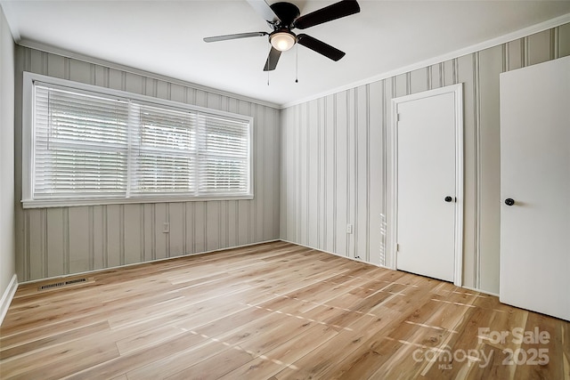 unfurnished bedroom featuring light wood-type flooring, ceiling fan, and crown molding