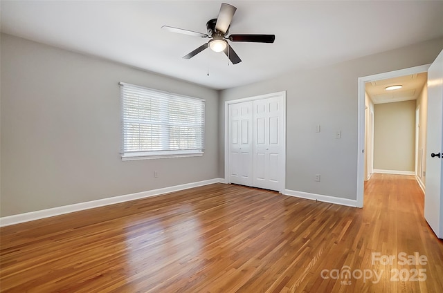 unfurnished bedroom with a closet, ceiling fan, and hardwood / wood-style flooring