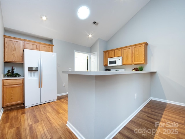 kitchen featuring white appliances, kitchen peninsula, high vaulted ceiling, and light hardwood / wood-style flooring