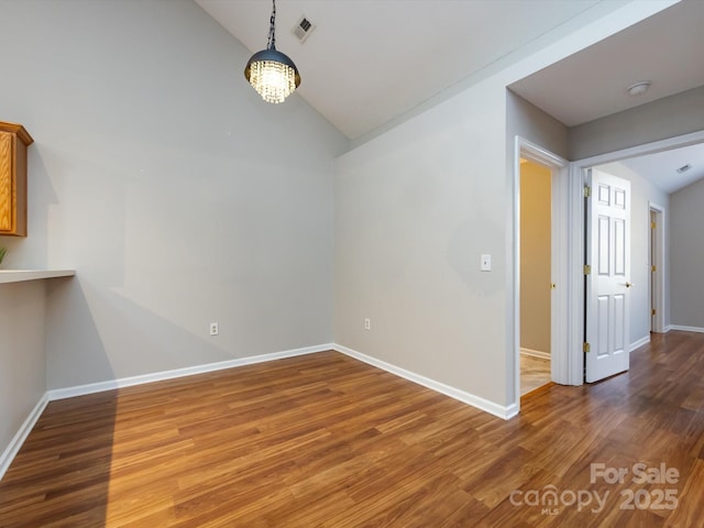 spare room featuring dark hardwood / wood-style floors and vaulted ceiling