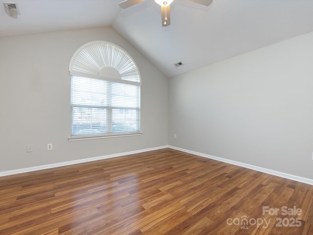 empty room with ceiling fan, dark wood-type flooring, and lofted ceiling