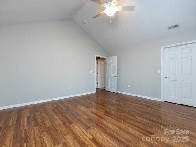 unfurnished bedroom featuring dark hardwood / wood-style flooring, vaulted ceiling, and ceiling fan