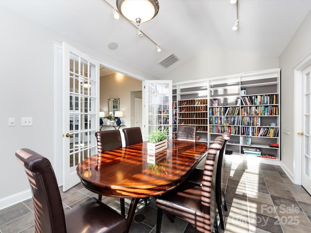 dining space featuring tile patterned flooring, french doors, and vaulted ceiling