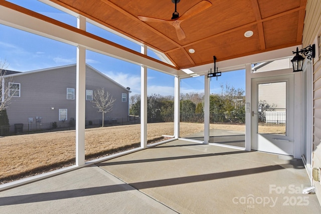 unfurnished sunroom featuring ceiling fan, vaulted ceiling, and wooden ceiling