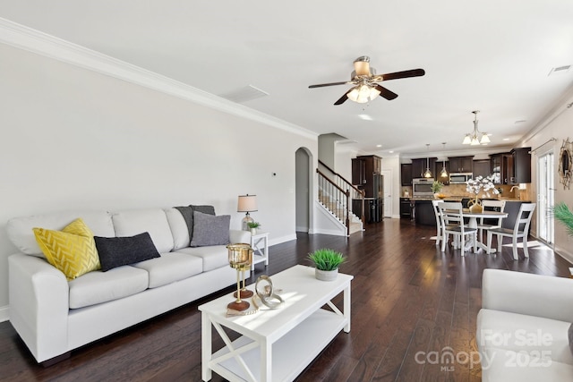 living room featuring crown molding, dark hardwood / wood-style floors, and ceiling fan with notable chandelier