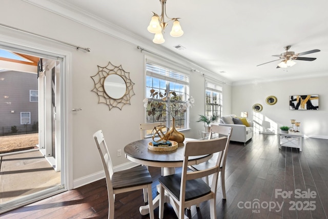 dining area featuring crown molding, ceiling fan with notable chandelier, and dark hardwood / wood-style flooring