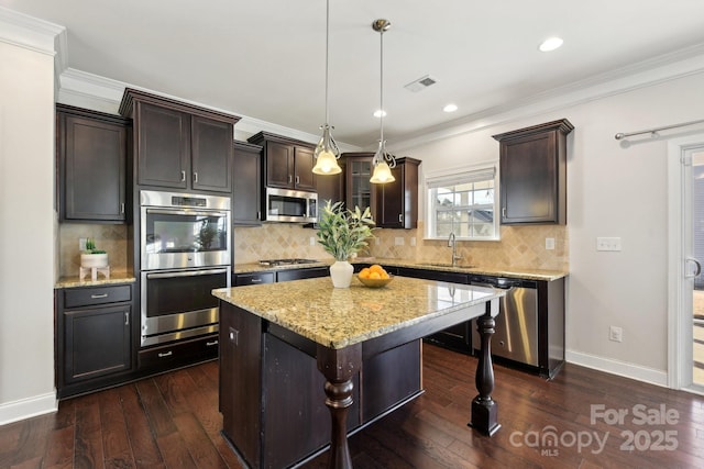 kitchen with pendant lighting, dark brown cabinetry, stainless steel appliances, and a center island