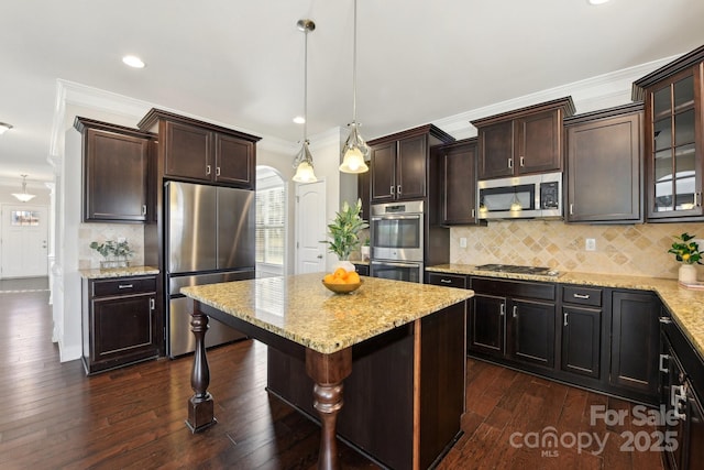 kitchen with dark brown cabinets, stainless steel appliances, and hanging light fixtures