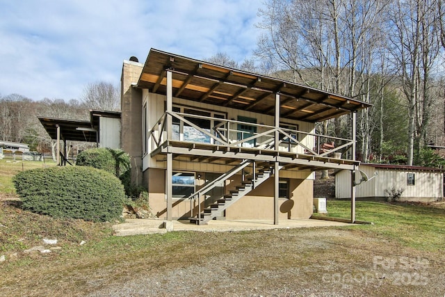 rear view of property with an outdoor structure