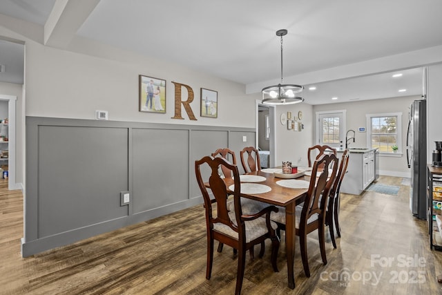 dining area featuring hardwood / wood-style flooring, sink, and a chandelier