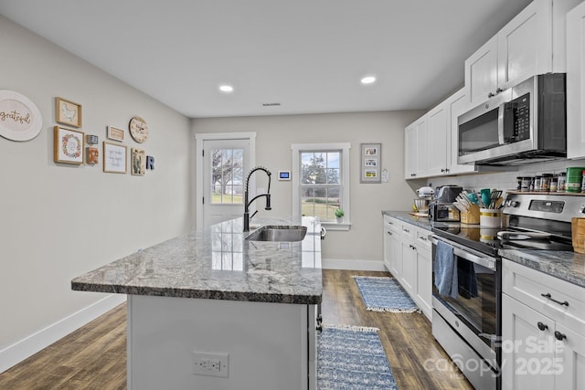 kitchen with white cabinets, sink, stainless steel appliances, and a kitchen island with sink