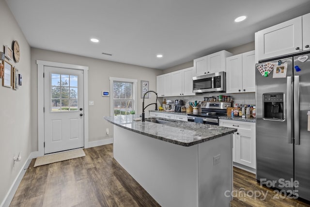 kitchen featuring white cabinets, sink, an island with sink, and stainless steel appliances