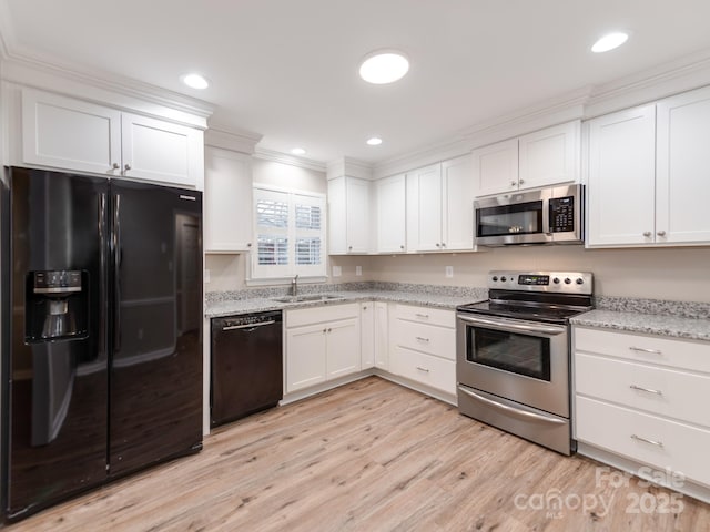 kitchen featuring white cabinetry, sink, black appliances, and light wood-type flooring