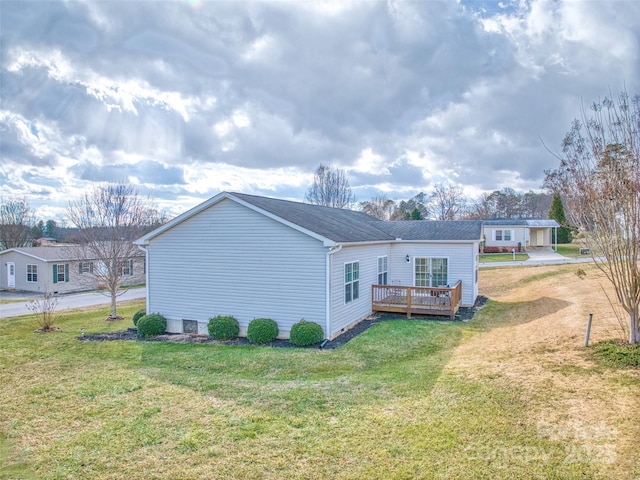 rear view of property with a lawn and a deck