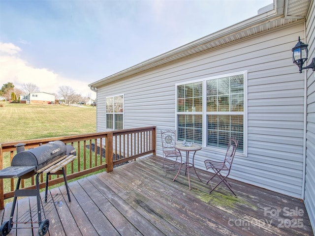 wooden deck with a yard and grilling area