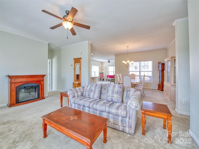 living room featuring ceiling fan with notable chandelier, light colored carpet, and crown molding