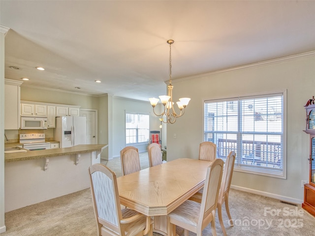 carpeted dining space featuring a notable chandelier, sink, plenty of natural light, and ornamental molding