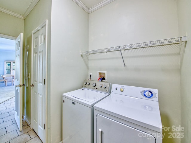 laundry area featuring washer and clothes dryer, light tile patterned flooring, and ornamental molding