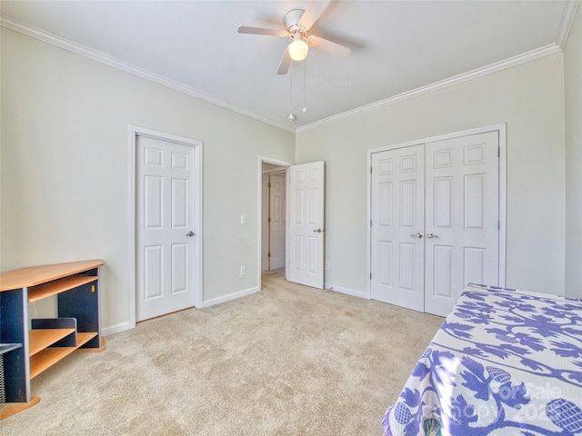 carpeted bedroom with a closet, ceiling fan, and crown molding