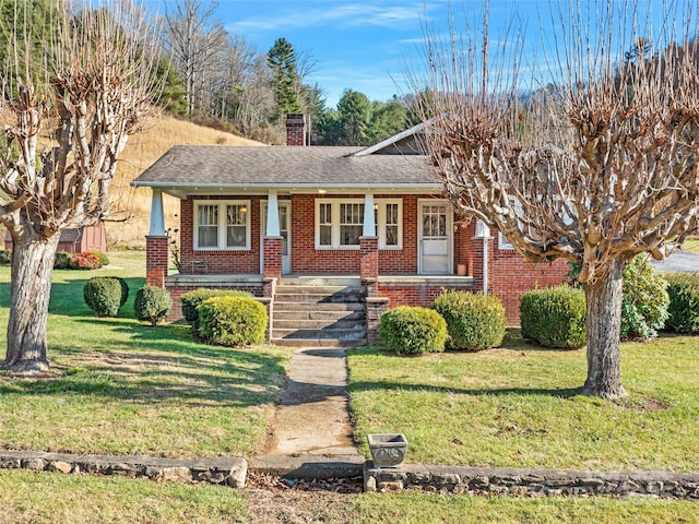 view of front of house featuring covered porch and a front lawn