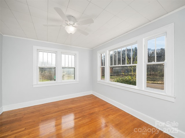 empty room featuring crown molding, hardwood / wood-style floors, and ceiling fan