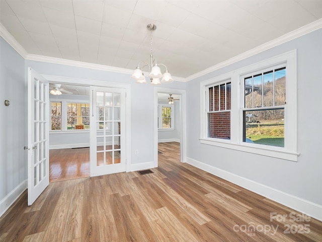 unfurnished dining area with hardwood / wood-style flooring, crown molding, and french doors