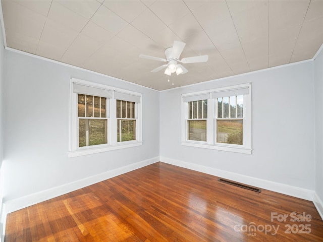 empty room featuring hardwood / wood-style flooring, ornamental molding, and ceiling fan