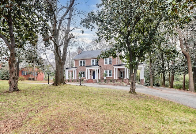 colonial home featuring a front yard