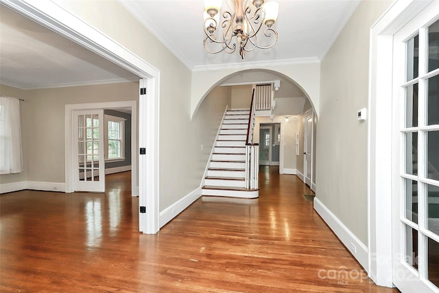 corridor featuring a notable chandelier, wood-type flooring, and crown molding