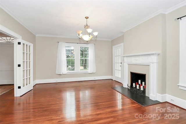 unfurnished living room with a chandelier, hardwood / wood-style flooring, and crown molding