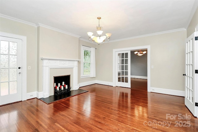 unfurnished living room with hardwood / wood-style floors, a chandelier, ornamental molding, and french doors