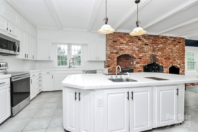 kitchen with beam ceiling, sink, stainless steel appliances, an island with sink, and white cabinets