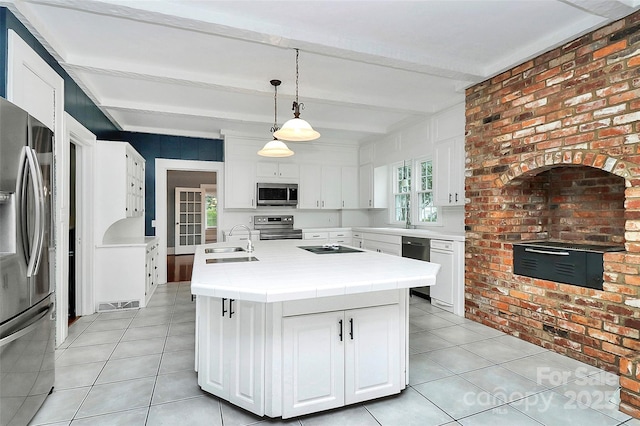 kitchen with appliances with stainless steel finishes, sink, white cabinetry, and beam ceiling