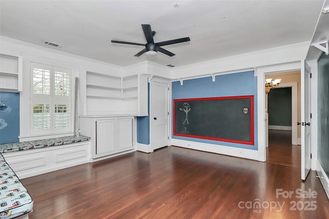 unfurnished living room featuring ceiling fan with notable chandelier, dark hardwood / wood-style floors, crown molding, and built in shelves