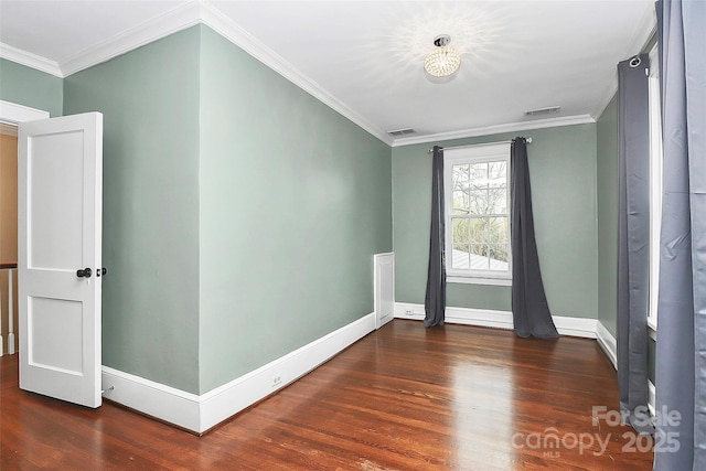 empty room with dark hardwood / wood-style flooring and crown molding