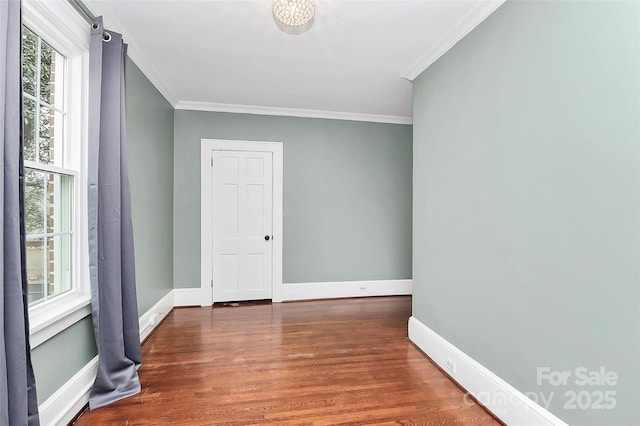 spare room featuring dark hardwood / wood-style flooring and ornamental molding