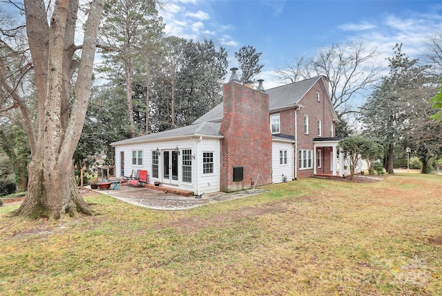 rear view of property with a yard and a patio area