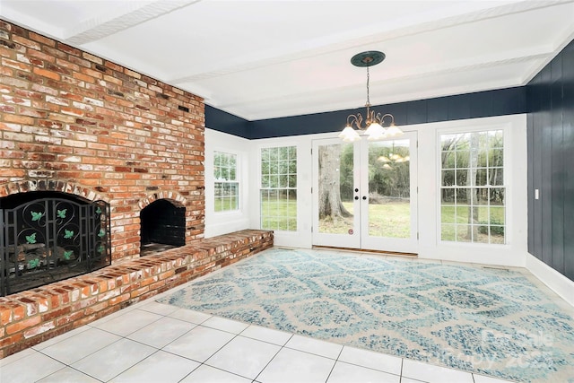 tiled living room with beam ceiling, french doors, a fireplace, and a chandelier