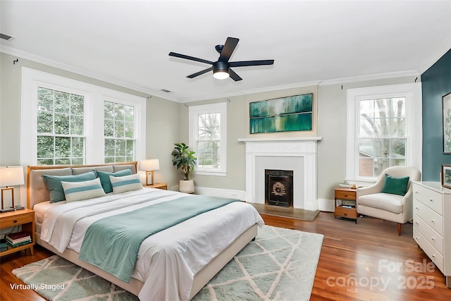 bedroom featuring multiple windows, hardwood / wood-style floors, and ceiling fan