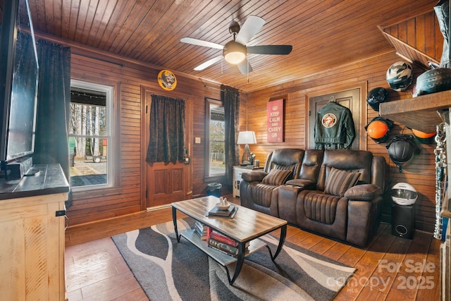 living room featuring hardwood / wood-style flooring, ceiling fan, wood ceiling, and wooden walls